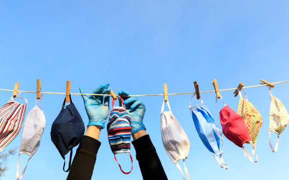 Drying mask hanging under the sun after use for disinfecting. Hygienic mask hanging on the rack outdoor after being washed for cleanness and hygiene during Covid-19 virus outbreak