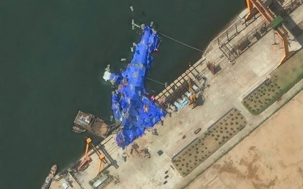 This handout satellite image courtesy of Maxar Technologies taken on May 23, 2025, shows a general view of a new North Korean warship at the harbor after its launch accident in Chongjin. North Korea has begun an investigation into the accident that occurred during the May 21, 2025, launch, state media said on May 23, 2025, assessing the damage as "not serious". (Photo by Handout / Satellite image ©2025 Maxar Technologies / AFP) / RESTRICTED TO EDITORIAL USE - MANDATORY CREDIT "AFP PHOTO/ SATELLITE IMAGE ©2025 MAXAR TECHNOLOGIES" - NO MARKETING NO ADVERTISING CAMPAIGNS - DISTRIBUTED AS A SERVICE TO CLIENTS - THE WATERMARK MAY NOT BE REMOVED/CROPPED
