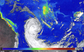 A false colour satellite image of a cyclone off the east coast of Australia, with phytoplankton blooms coloured green and red along the coast and in the Pacific.