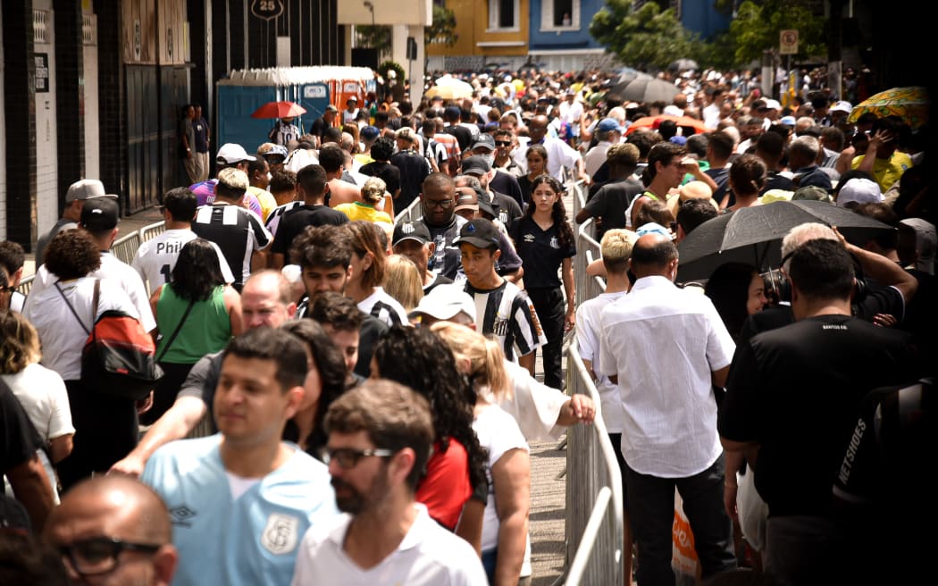 Fans queue to see and give their last tributes and farewell to Pele at the Vila Belmiro stadium, home of Santos Football Club.