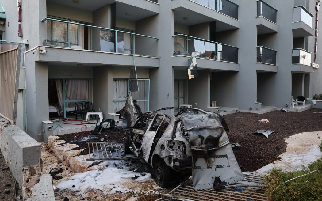 A picture taken outside a hotel in the southern Israeli city of Ashkelon shows a car destroyed in a rocket attack from the Gaza Strip on October 10, 2023. Israel said it recaptured Gaza border areas from Hamas militants as the war's death toll passed 3,000 on October 10, the fourth day of fierce fighting since the Islamists launched a surprise attack.