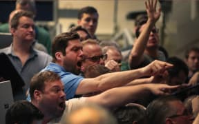 Traders signal offers in the S&P options pit in Chicago.