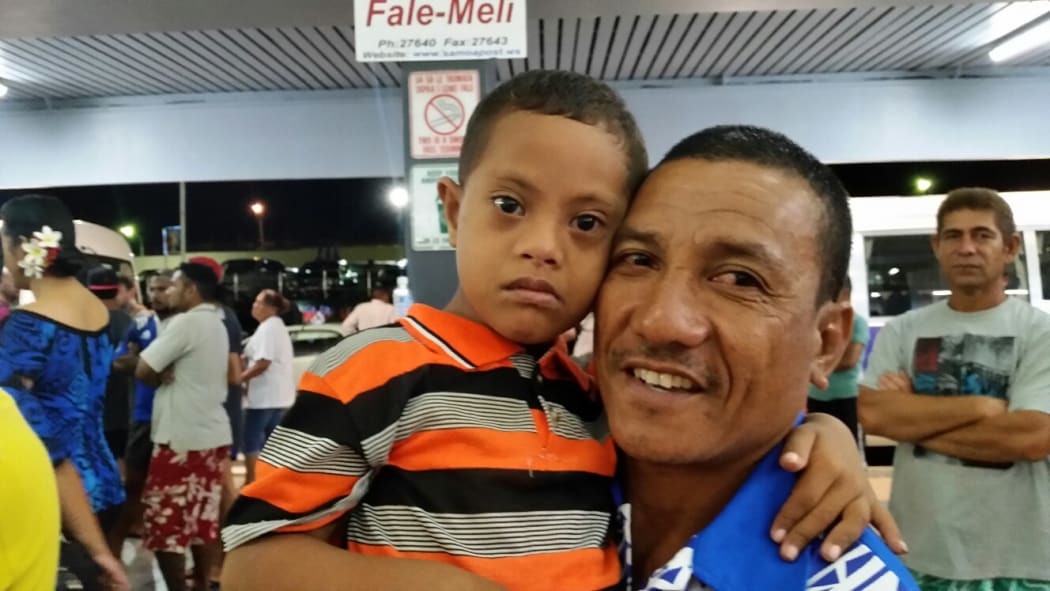 Five-year-old Richard and his father, Melia, await the All Blacks arrival at Faleolo Airport.