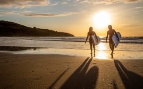 Surfers on Ngarunui Beach, Waikato
