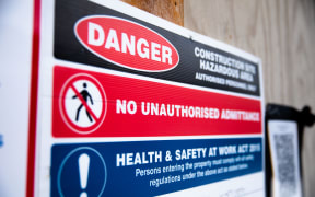 A sign warns of hazards on a building site