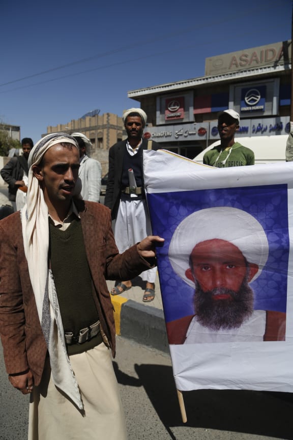 A man holds a portrait of Shia cleric Sheikh Nimr Baqir al-Nimr sentenced to death in Saudi Arabia