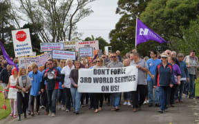 Phyl Phipps, 90, (far right) and Anita Halsall-Quinlan (far left) help lead more than 2000 protestors around Westport's Victoria Square.