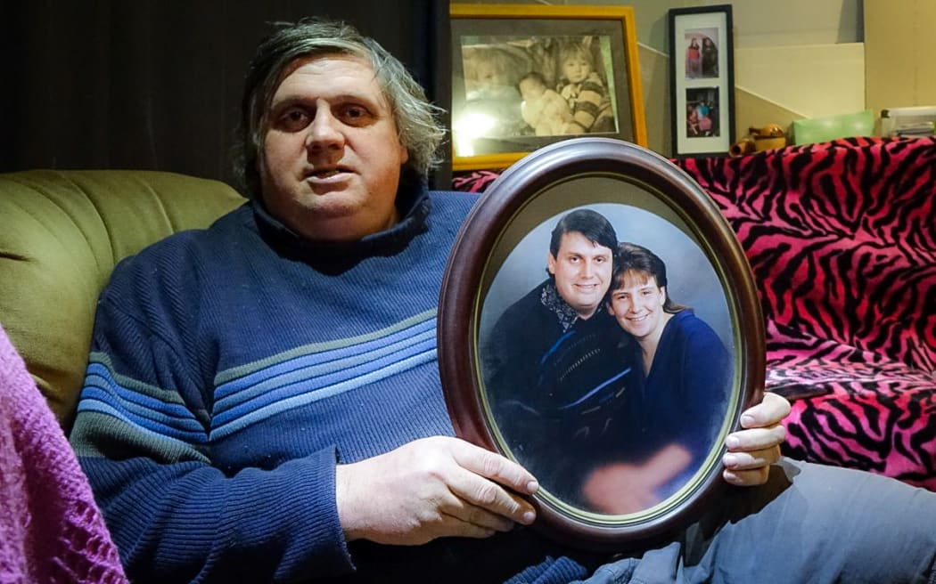 Laurie Anderson holds a photo of himself with partner Angela Blackmoore, who was murdered in their home 20 years ago.