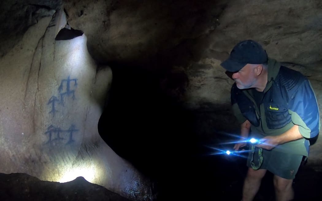 Ron Bull of Oraka Aparima examines ancient rock art in Taiari-Chalky Inlet