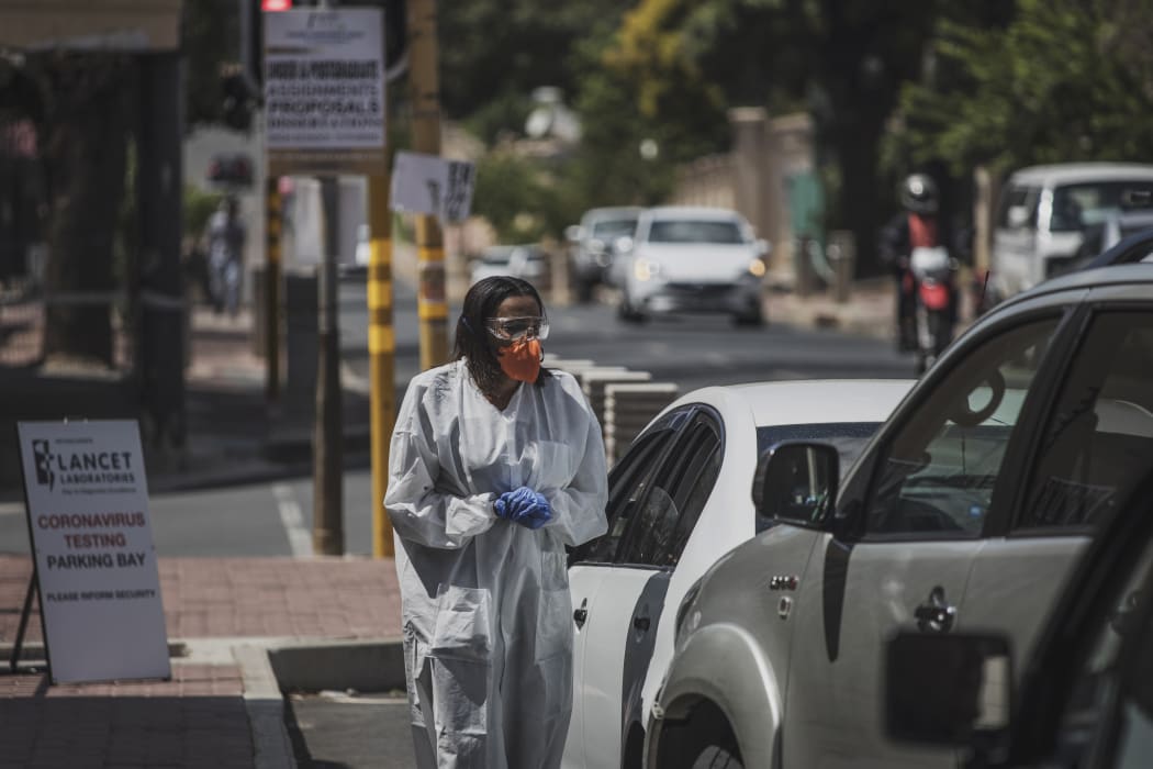 A health professional conducts a COVID-19 coronavirus test at a drive through testing site outside the Lancet Laboratories facilities in Johannesburg.