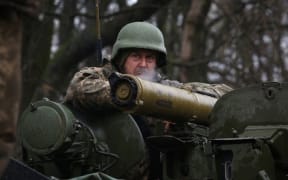 A Ukrainian soldier stands on an armoured personnel carrier (APC), not far from the frontline with Russian troops, in Izyum district, Kharkiv region on 18 April, 2022.