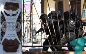 Indonesian police prepare to raid the dormitory.