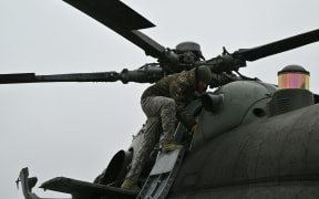 A Ukrainian serviceman of an Army Aviation Brigade prepares a Mi-8 helicopter to fly in the Donetsk region on December 7, 2023, amid the Russian invasion of Ukraine. (Photo by Genya SAVILOV / AFP)