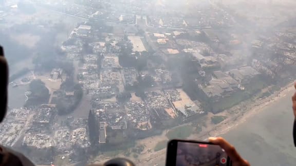 This handout video grab courtesy of Richard Olsten taken on August 9, 2023 shows smoke billowing from destroyed buildings in Lahaina as wildfires burn across Maui, Hawaii. At least six people have been killed in a wildfire that has razed a Hawaiian town, officials said Wednesday, as desperate residents jumped into the ocean in a bid to escape the fast-moving flames.