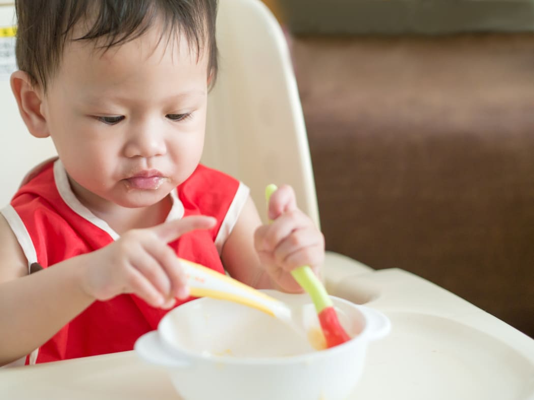 Asian toddler eating a meal