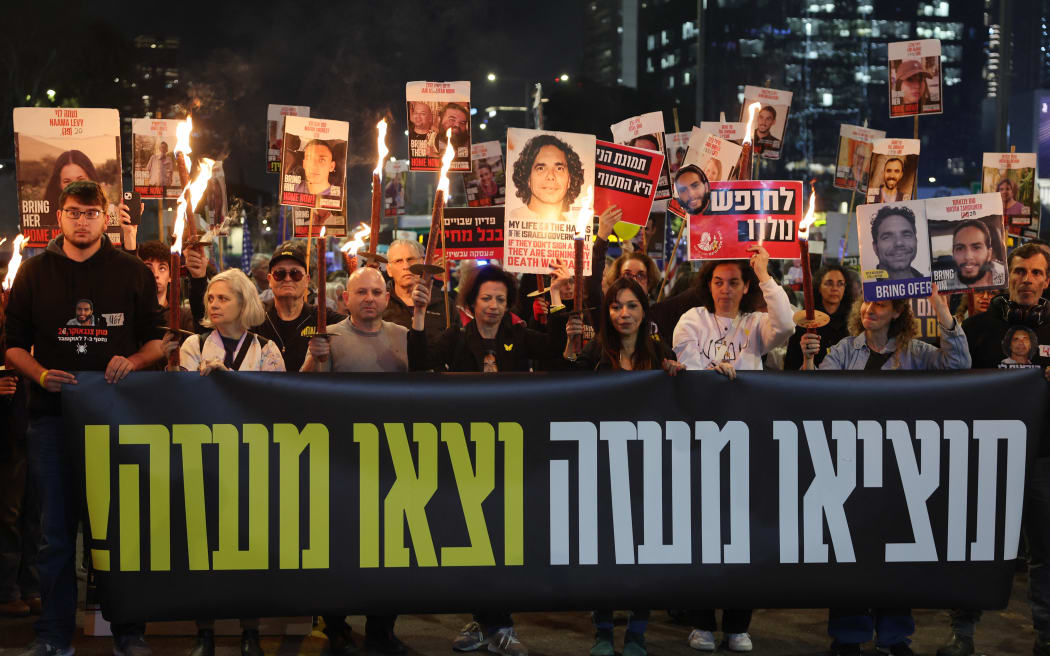 Demonstrators take part in a protest calling for action to secure the release of Israelis held hostage in Gaza since the October 2023, in front of the Israeli defence ministry in Tel Aviv on January 15, 2025, amid the ongoing war between Israel and the militant Hamas group. Israel said on January 15 that several points in the Gaza ceasefire and hostage release deal still needed to be resolved but expected them to be "finalised tonight," even as news spread that an agreement with Hamas had been reached. (Photo by Jack GUEZ / AFP)