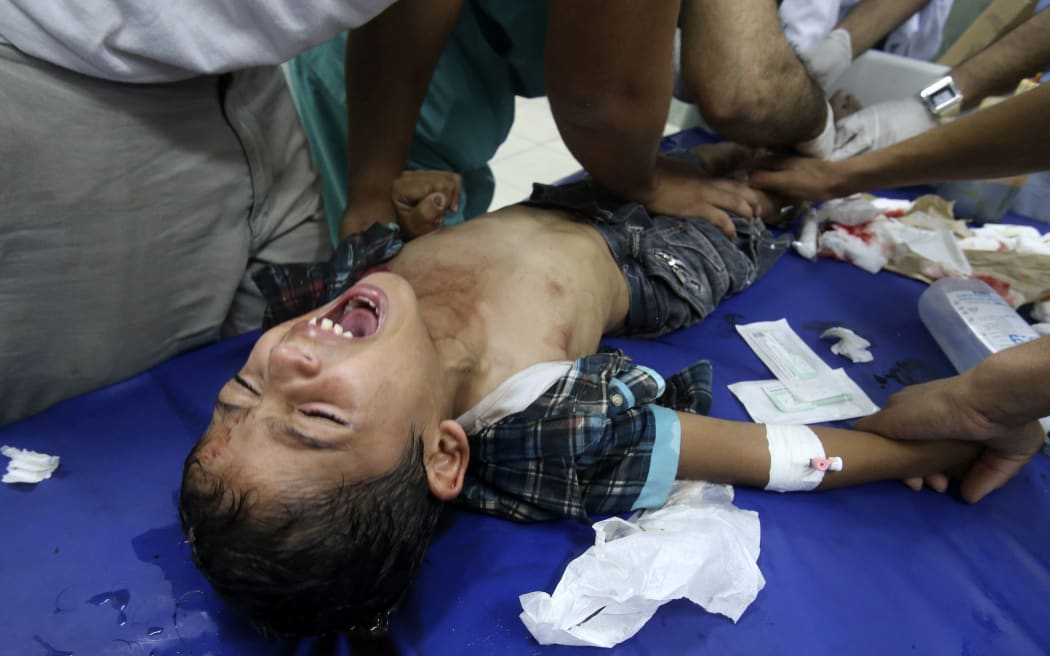 Medics tend to a boy injured in the shelling of a Gaza hospital.