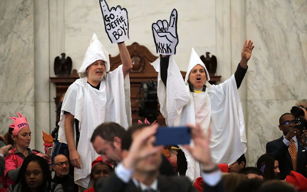 Protesters wearing white sheets shout at Sen. Jeff Sessions as he arrives for his confirmation hearing to be the US attorney general.