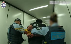 A man is led away by police.