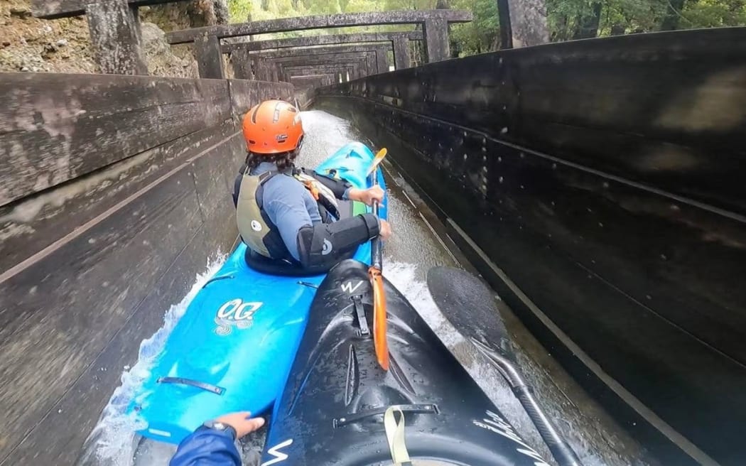 Jerremy Norbury (front) and friend Zack Mutton kayaking down a drainage ditch in Hokitika.