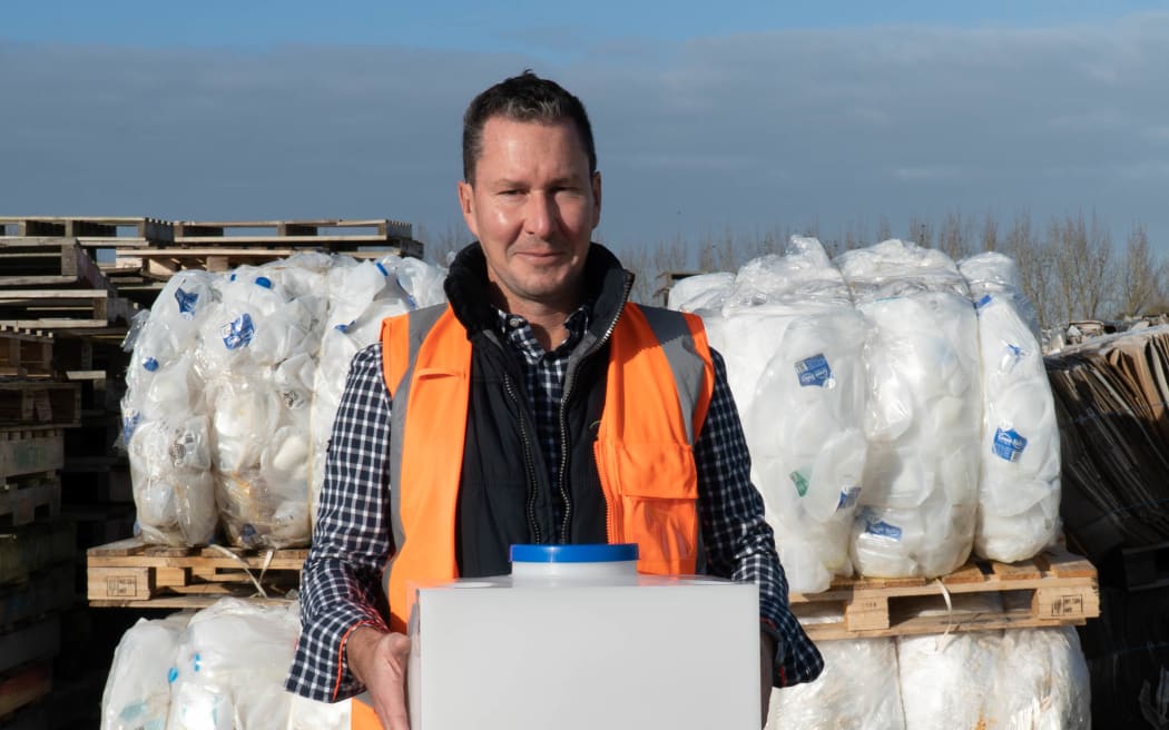 Green Valley Dairies general manager Mark Pulman holds a refillable milk keg. He says farmers are getting on board with being more environmentally conscious.