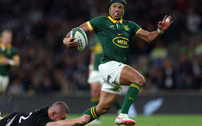 South Africa's wing Kurt-Lee Arendse breaks clear to score a try during the match between New Zealand and the Springboks at Twickenham Stadium.