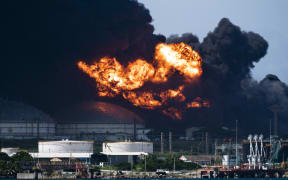 View of the massive fire at a fuel depot, sparked overnight by a lightning strike, in Matanzas, in western Cuba, taken on August 6, 2022. - Cuba asked for help Saturday to contain the massive fire that left 77 people injured and 17 firefighters missing. Some 800 people have been evacuated from the area. (Photo by Yamil LAGE / AFP)
