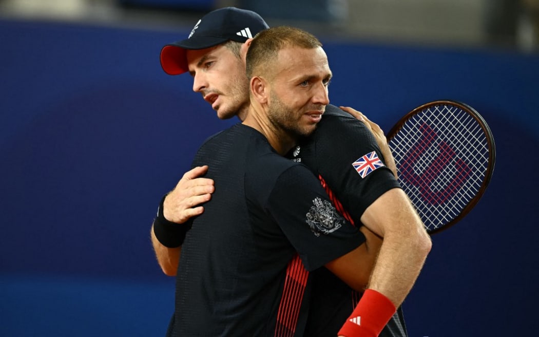 Britain's Andy Murray embraces Britain's Daniel Evans after their defeat to US' Taylor Fritz and US' Tommy Paul in their men's doubles quarter-final tennis match on Court Suzanne-Lenglen at the Roland-Garros Stadium during the Paris 2024 Olympic Games, in Paris on August 1, 2024. (Photo by CARL DE SOUZA / AFP)