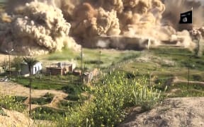 An image grab taken from a video made available by the Jihadist media outlet Welayat Nineveh showing explosives being detonated at the site.