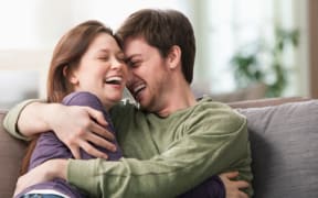 Caucasian couple hugging on sofa