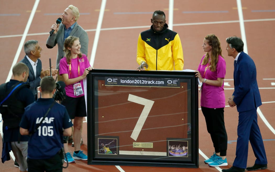 Usain Bolt receives a section of the London track after retiring, 2017.