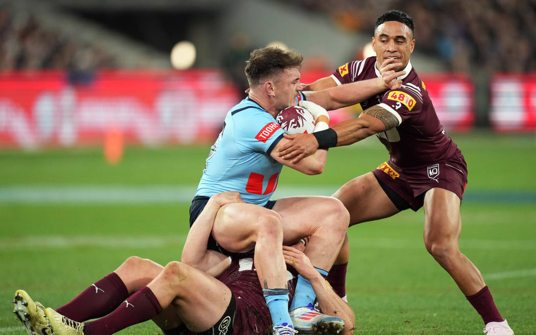 Angus Crichton of the Blues is tackled by Valentine Holmes of the Maroons during the State of Origin Game Two match between the New South Wales Blues and the Queensland Maroons at the Melbourne Cricket Ground in Melbourne, Wednesday, June 26, 2024. (AAP Image/Joel Carrett/ Photosport)