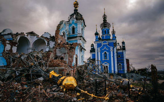 Construction workers climb onto the roof of a destroyed church in the village of Bohorodychne, Donetsk region on January 4, 2023, amid the Russian invasion of Ukraine. - Bohorodychne is a village in Donetsk region that came under heavy attack by Russian forces in June 2022, during the Russian invasion of Ukraine. On August 17, 2022 the Russian forces captured the village. The Armed Forces of Ukraine announced on September 12, 2022 that they took back the control over the village. A few resident came back to restore their destroyed houses and live in the village. (Photo by Dimitar DILKOFF / AFP)