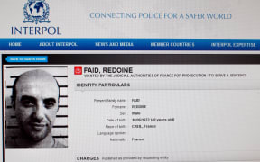 This file photo taken on April 15, 2013 in Paris shows a reproduction of the Interpol website shows the international wanted person notice for French robber Redoine Faid.