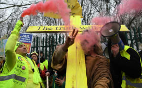 A supporter of WikiLeaks founder Julian Assange, holds a flare as he calls for Assange's freedom outside Woolwich Crown Court