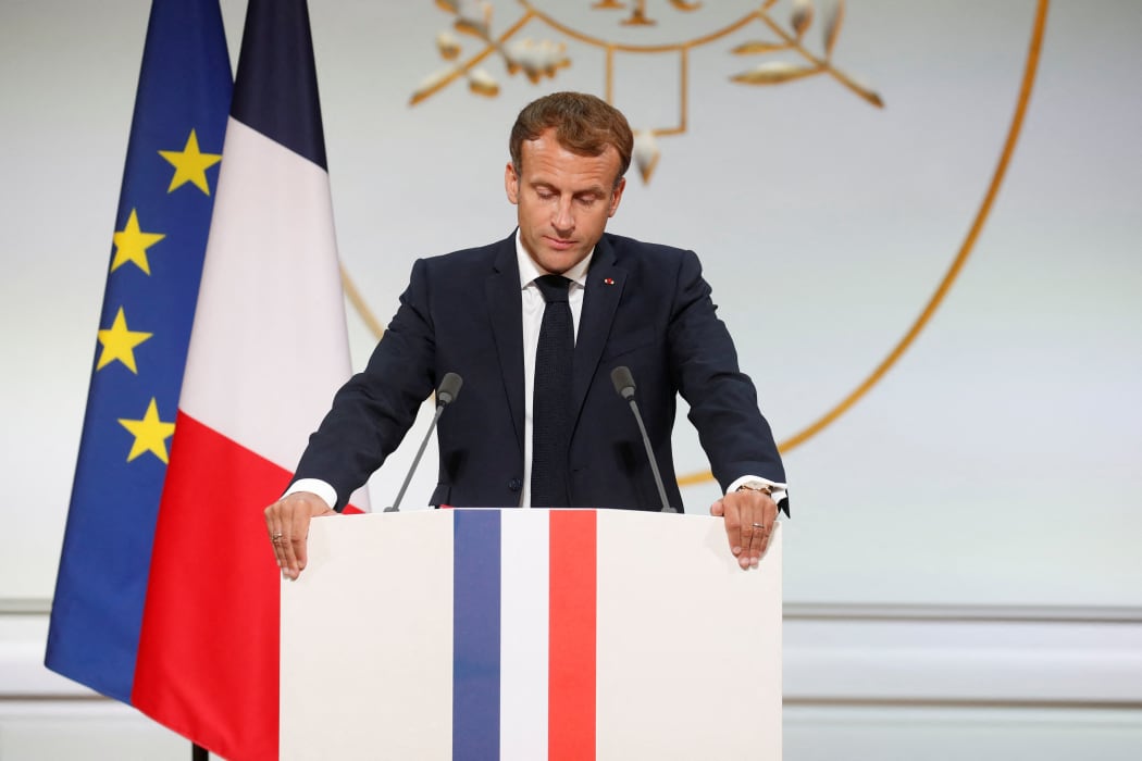TOPSHOT - French president Emmanuel Macron delivers a speech during a ceremony in memory of the Harkis, Algerians who helped the French Army in the Algerian War of Independence, at the Elysee Palace in Paris, on September 20, 2021.
