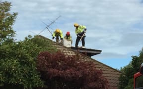 Firefighters are smash down a chimney after reports a man is trapped.