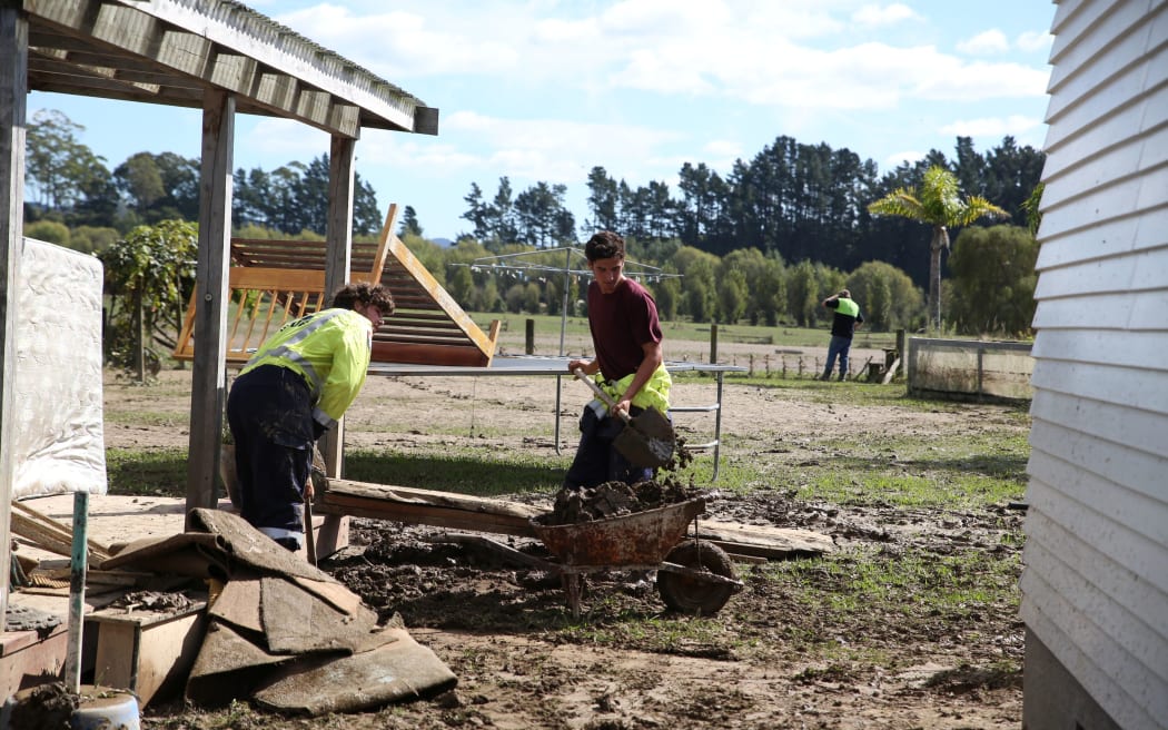 Volunteers help clean up the flood mess at Graham Lyford's place.
