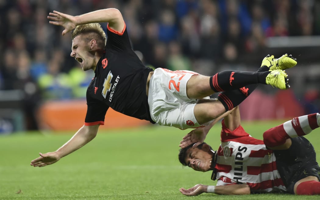 Manchester United defender Luke Shaw is challenged by PSV Eindhoven's Mexican defender Hector Moreno during the UEFA Champions League Group B football match between PSV Eindhoven and Manchester United in Eindhoven on 16.9.15. AFP PHOTO / JOHN THYS