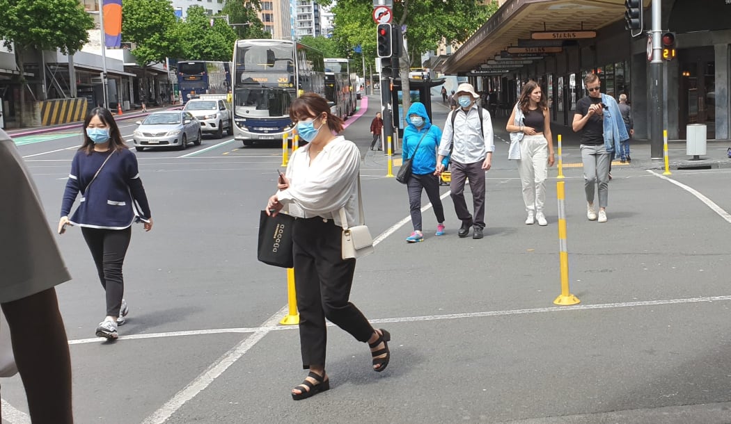 People in Queen Street Auckland, wearing masks.