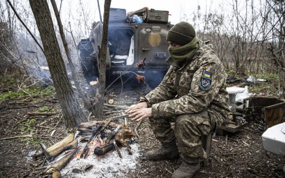 DONETSK OBLAST, UKRAINE - NOVEMBER 28: A Ukrainian soldier tries to warm up on the frontline, in Donetsk Oblast, Ukraine on November 28, 2022. As the war between Russia and Ukraine continues, rainy and cold weather conditions create difficulties for the soldiers in Donetsk Oblast, where the most intense conflicts take place. Metin Aktas / Anadolu Agency (Photo by Metin Aktas / ANADOLU AGENCY / Anadolu Agency via AFP)