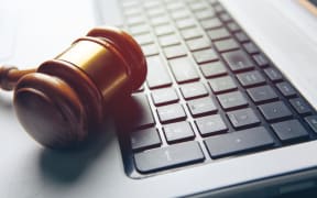 Close up view of a hammer and a computer keyboard.
