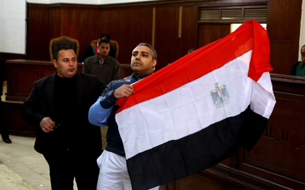 Mohamed Fahmy unfurls Egyptian flag during the hearing.