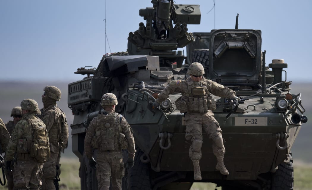 US Army serviceman jumps from armored vehicle during the NATO "Wind Spring 15" military exercise at Smardan military shooting range.