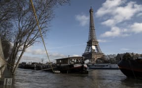 Barges are moored by the Eiffel Tower on the swollen Seine river in Paris.