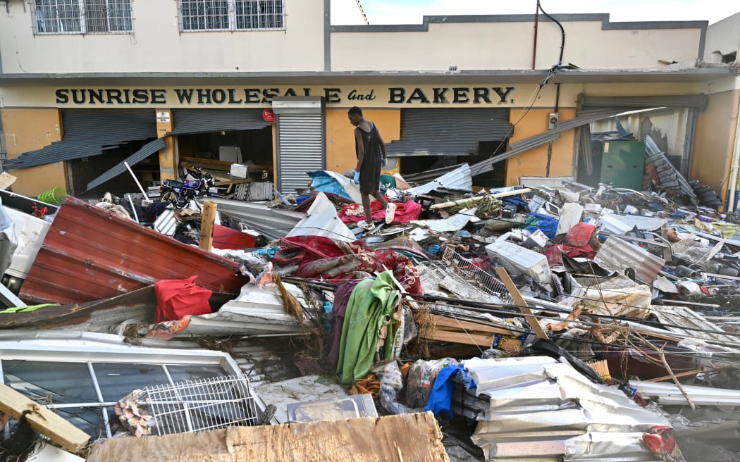 A young man walks on the rubble left on the street following the passage of Hurricane Melissa, in Black River, Jamaica.