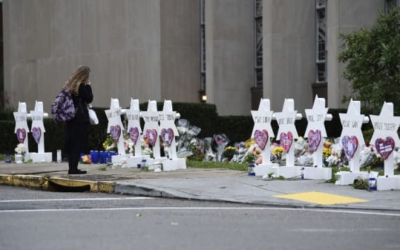 A woman stands at a memorial outside the Tree of Life synagogue in Pittsburgh after a shooting there left 11 people dead.