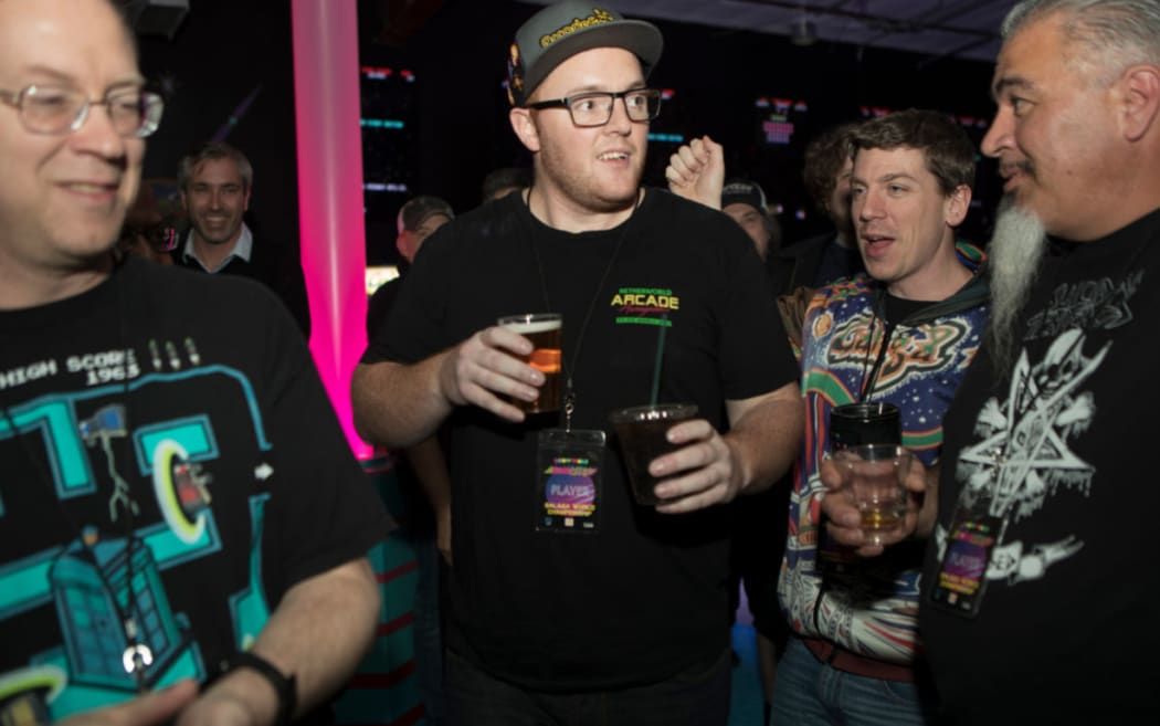 Andrew Barrow shares a beer with his fellow gamers.