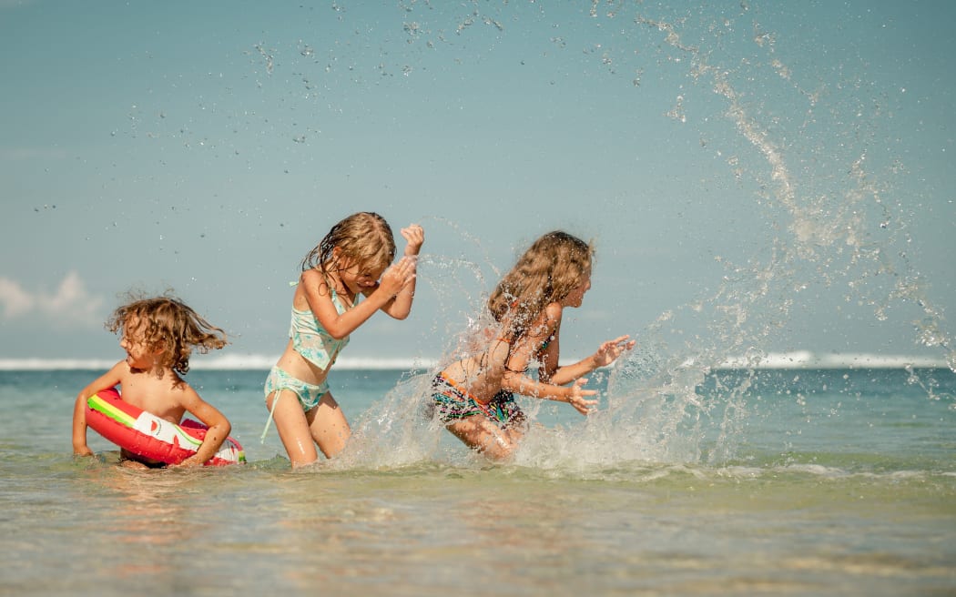 Happy kids playing on the beach at the day time - weather, heat, hot, summer, sun