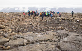 People attend a monument unveiling at site of Okjokull, Iceland's first glacier lost to climate change.